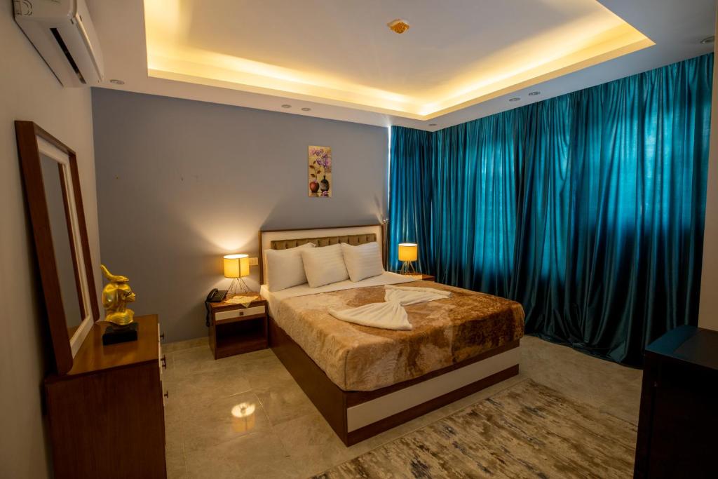 a bedroom with a large bed with blue curtains at El Shams Plaza Hotel in Cairo