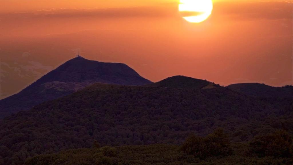 a view of a mountain with the sun setting behind it at Studio a Clermont Ferrand in Clermont-Ferrand