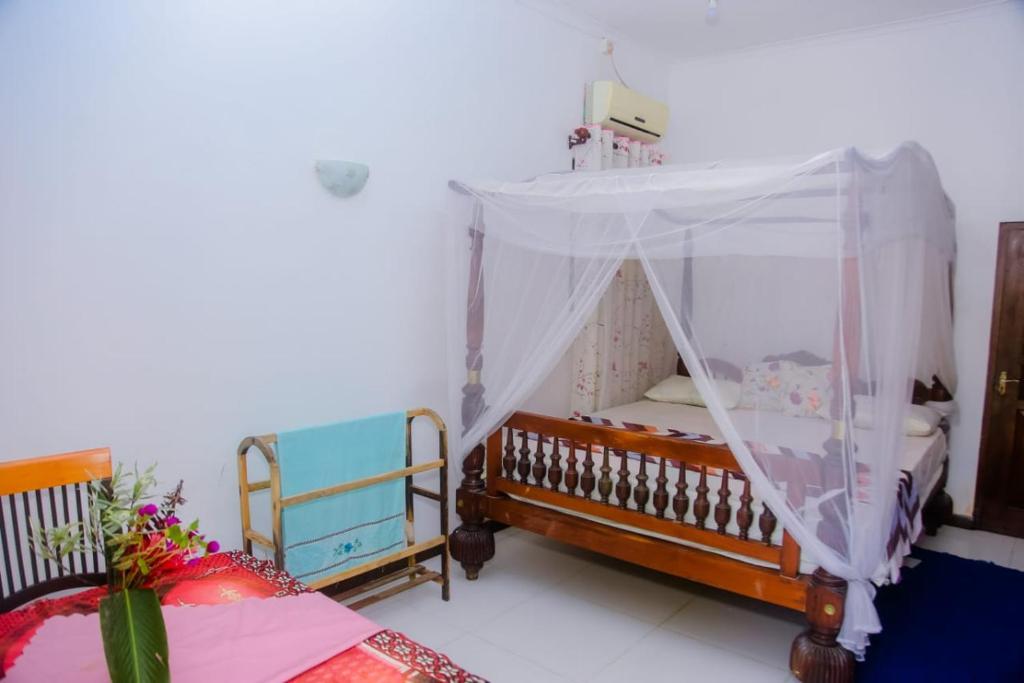 1 dormitorio con 1 cama con dosel en Seyoo Villa, en Ahangama