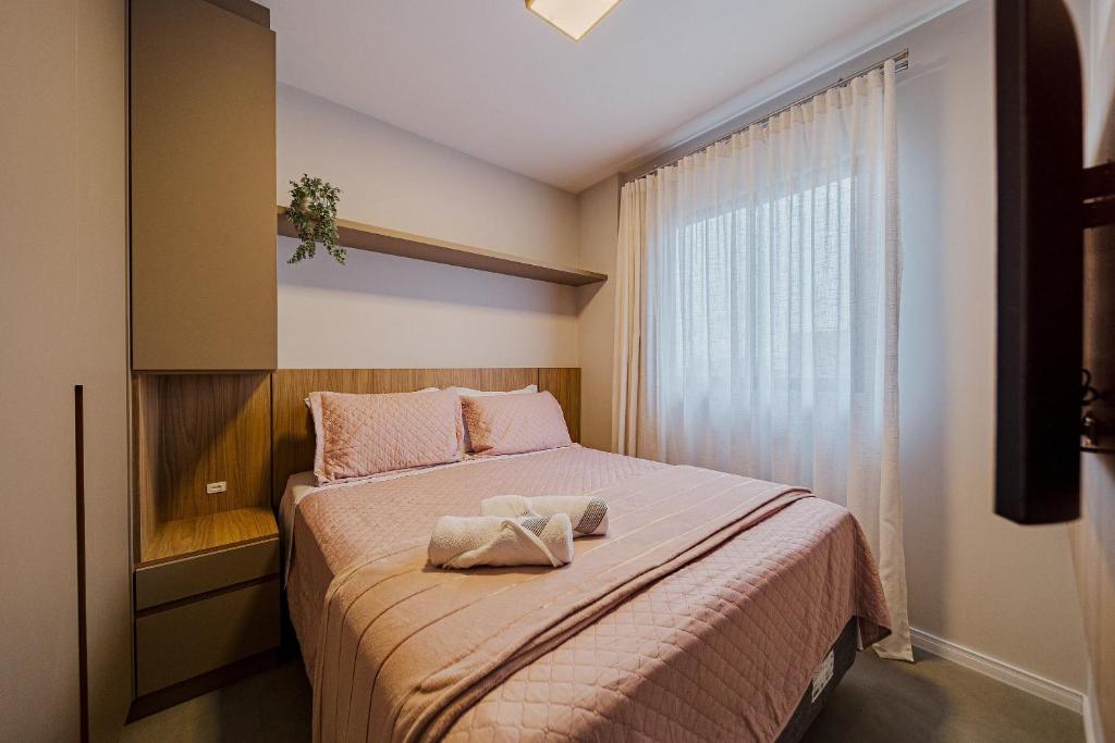 een slaapkamer met een bed met een handdoek erop bij 603 MORSE MUITO CONFORTO PARA SUA FAMILA in Joinville