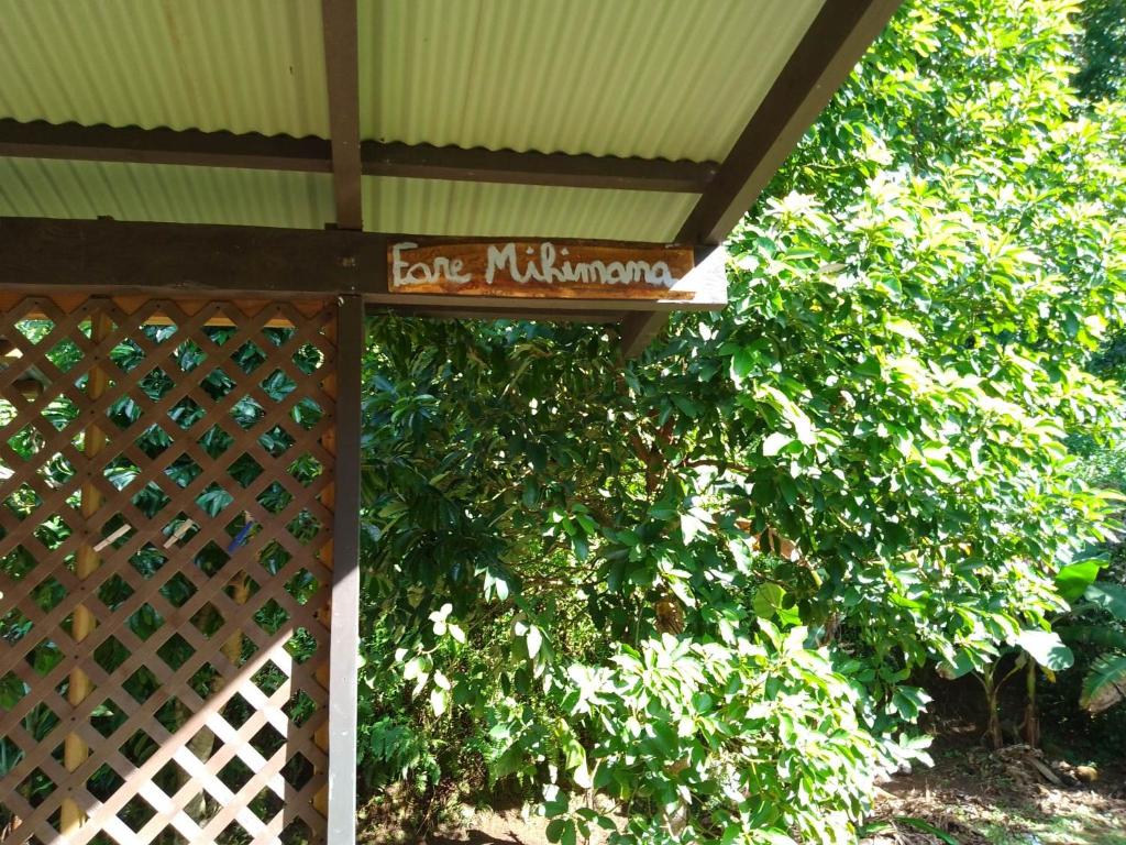 a sign that says cafe milwaukee in front of a bush at Fare Mihimana in Vaïare