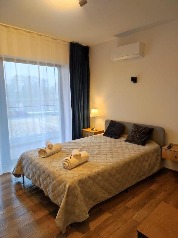 1 dormitorio con 1 cama con 2 toallas en Aquarius Stawy 1, en Grodzisk Mazowiecki