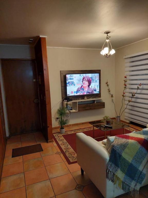 a living room with a couch and a flat screen tv at Apart Rayen in Los Ángeles