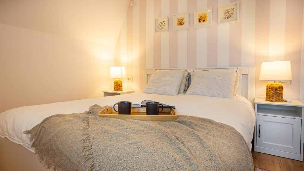 a bed with a tray with two mugs on it at Relax Cabins in Cristian