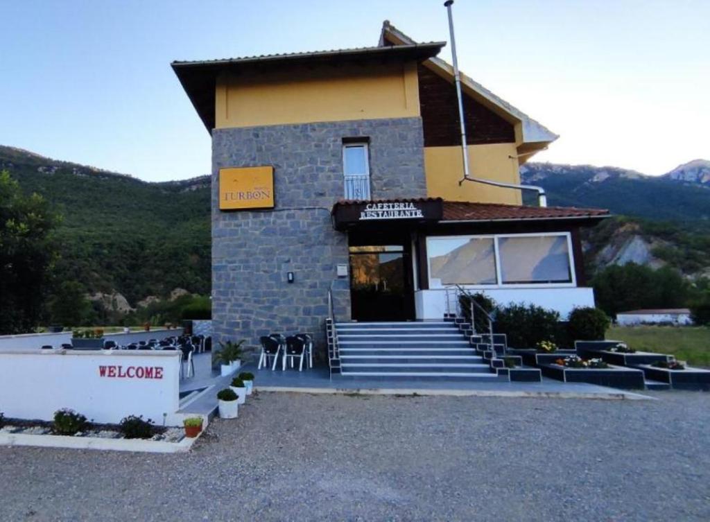 a small building with a staircase in front of it at Hostal Turbon in Campo