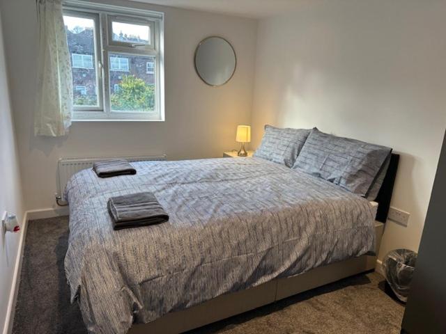 a bedroom with a bed and a window at Luton Home near Airport Private & Shared Bathroom Option in Luton