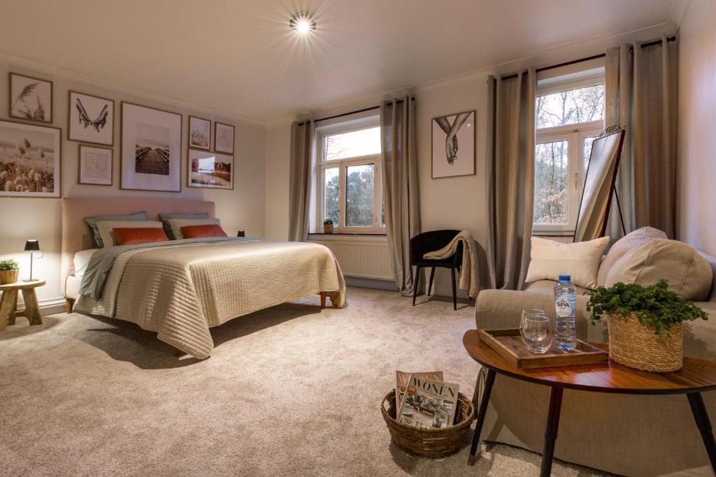 Vakantiewoning 'De Teut' في Zonhoven: غرفة نوم بسرير واريكة وطاولة