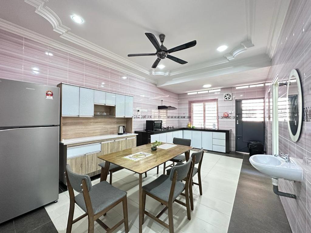 La cuisine est équipée d'une table à manger et d'un réfrigérateur. dans l'établissement Ipoh Cozy Premium Spacious Home, à Ipoh