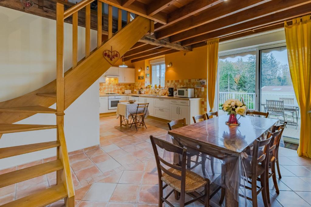 Gîte de charme, idéal pour 4 في Saint-Jory-de-Chaleix: مطبخ وغرفة طعام مع طاولة وكراسي خشبية