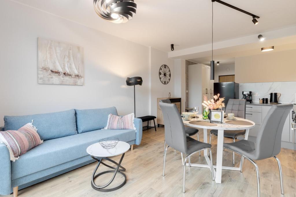 ザジェチェにあるA71 Laguna Beskidów Wellness&Spa Żeglarskiの青いソファとテーブルのあるリビングルーム