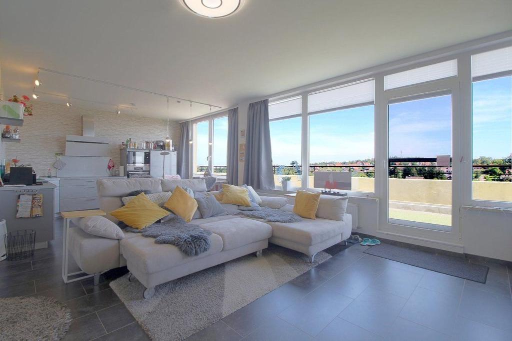 un soggiorno con divano bianco e ampie finestre di Penthouse 383 a Hohegeiss