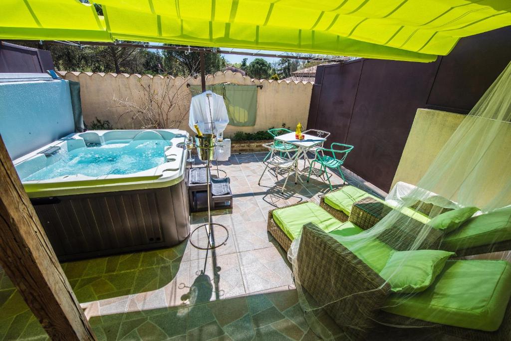 d'une terrasse avec un bain à remous et une table. dans l'établissement Gîte avec jacuzzi privatif dans un mas provençal, à Les Fumades-Les Bains