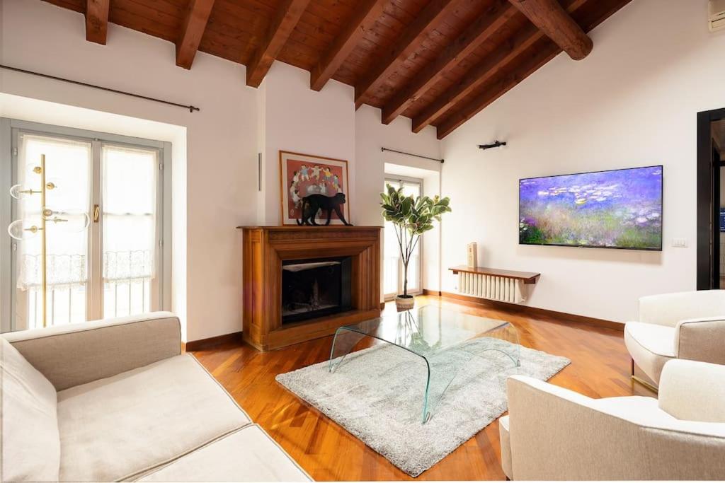 a living room with white furniture and a fireplace at Luxury apartment + private parking - Como center in Como