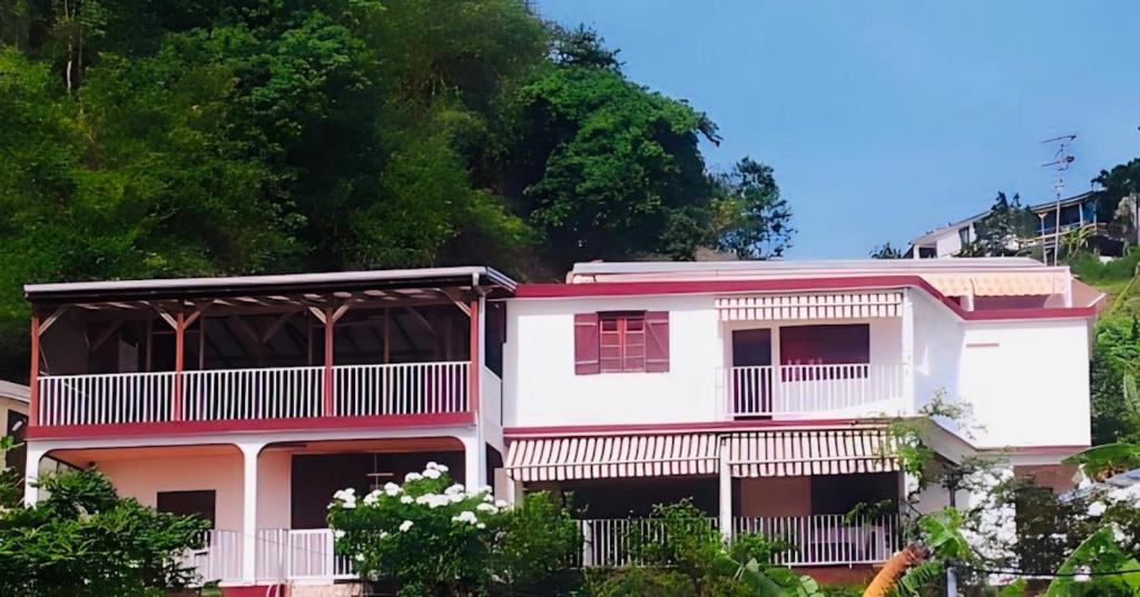 - un bâtiment blanc avec un balcon et des arbres dans l'établissement Logement entier au soleil couchant, à Deshaies