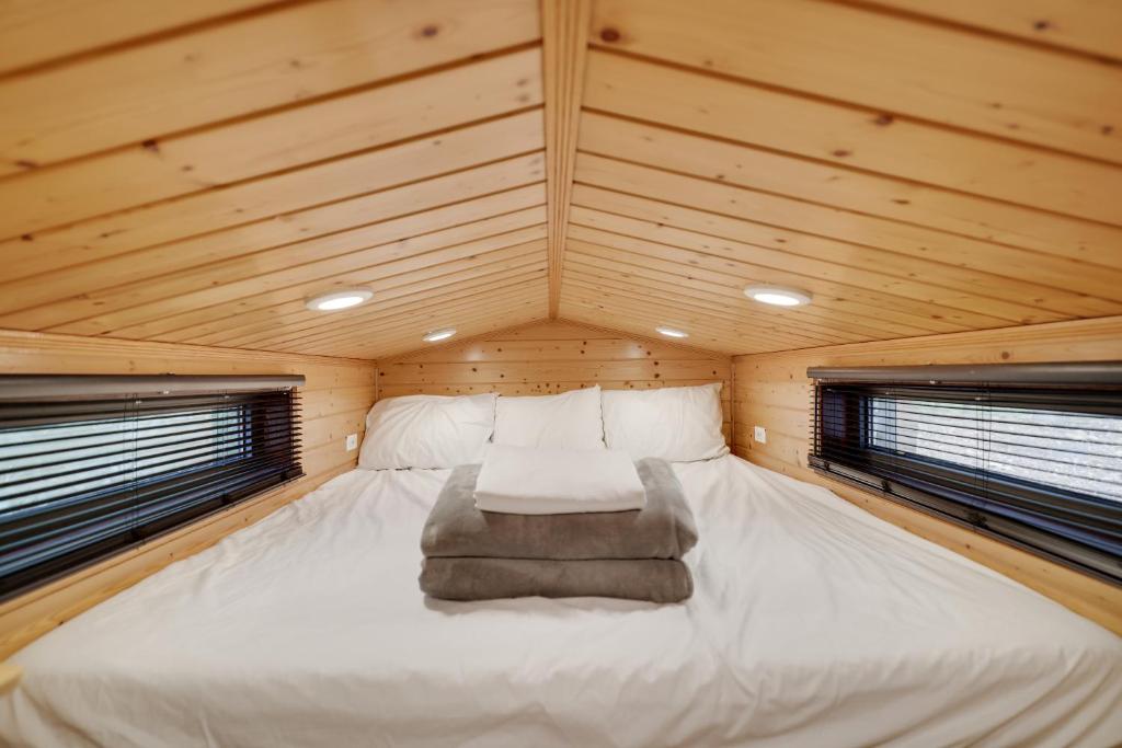 Albrightsville的住宿－Camptel Poconos Lodging，木间设有一张大床,设有两个窗户