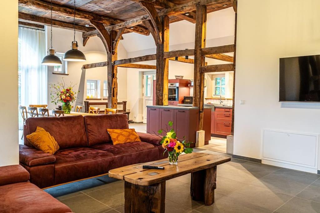 ein Wohnzimmer mit einem braunen Sofa und einem Tisch in der Unterkunft Ferienwohnung mit Sauna Zum alten Fritz in Versmold