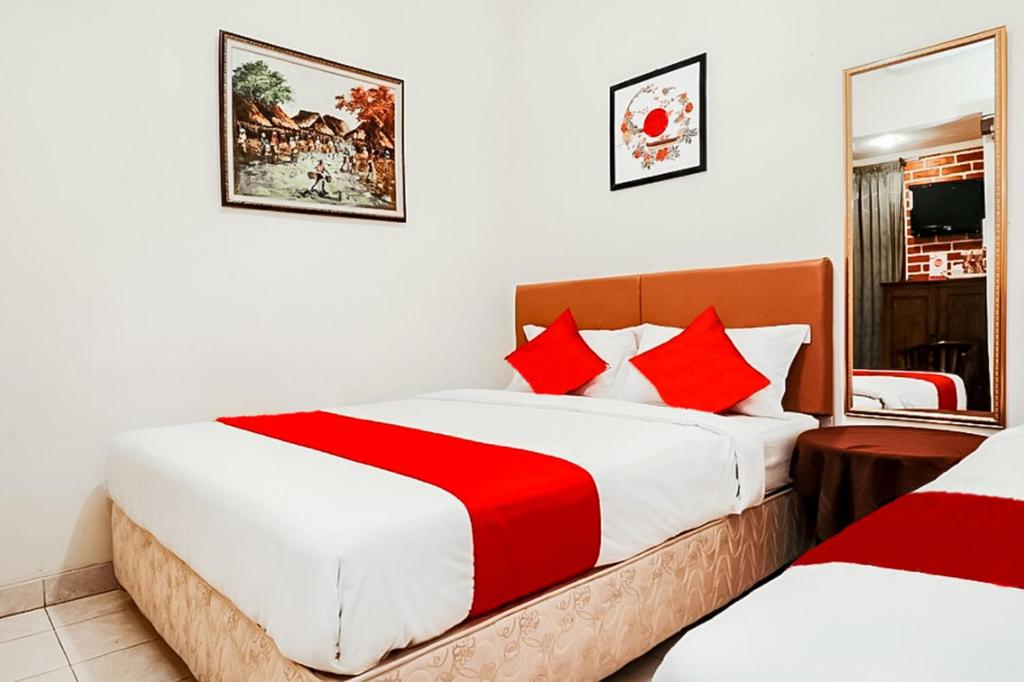 een slaapkamer met een groot bed met rode kussens bij The Homey Rooms and Tours in Yogyakarta