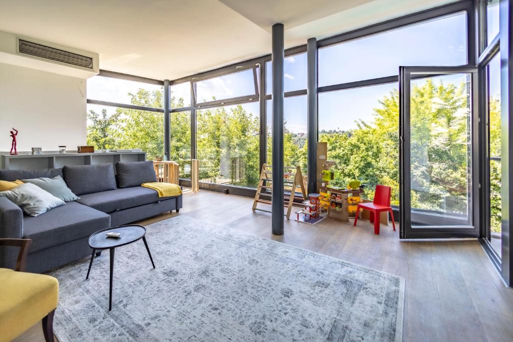 a living room with a couch and large windows at K13 House in Szentendre