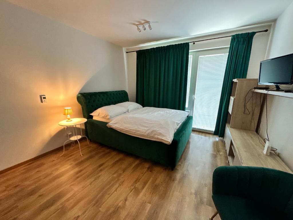 a small bedroom with a bed and a television at Entrez Apartments 5 - City center with small garden in Košice