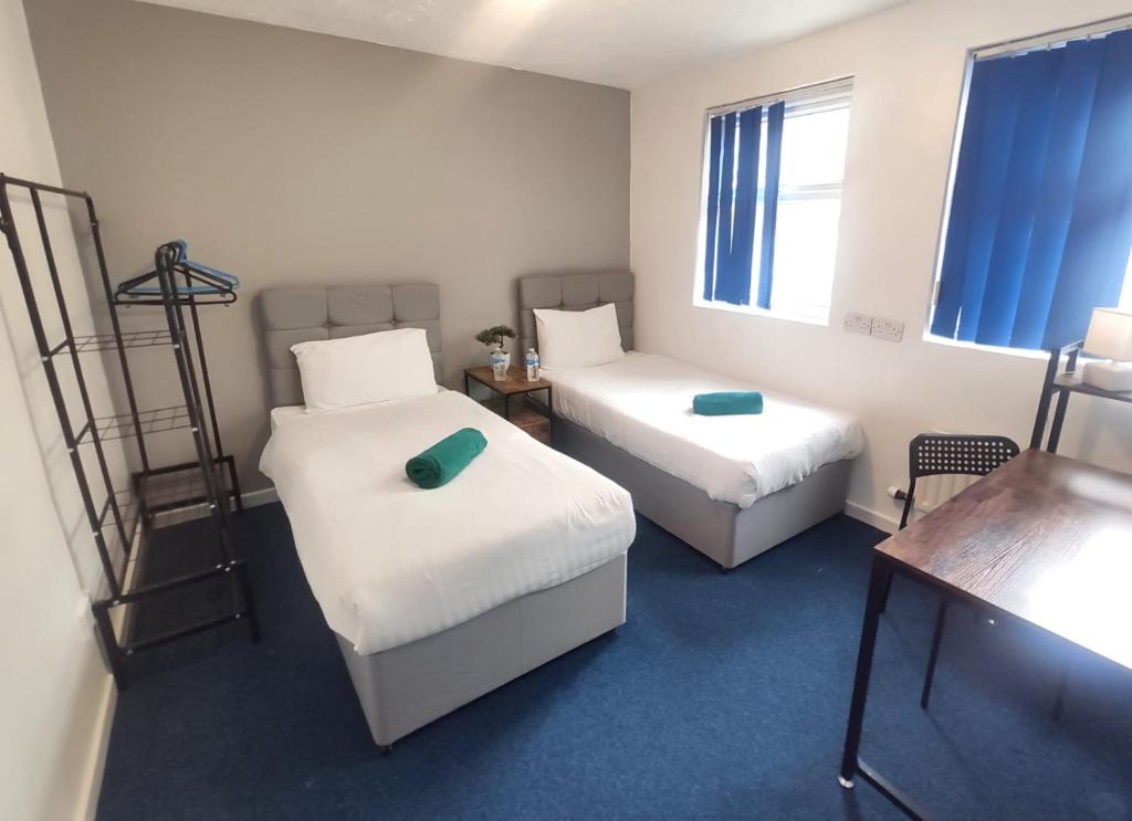a small room with two beds and a desk at Royal Chambers Liverpool in Liverpool