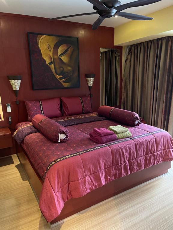 - une chambre avec un grand lit et une couette rose dans l'établissement Jomtien Plaza Residence B408 By Mr.Kiss, à Jomtien Beach