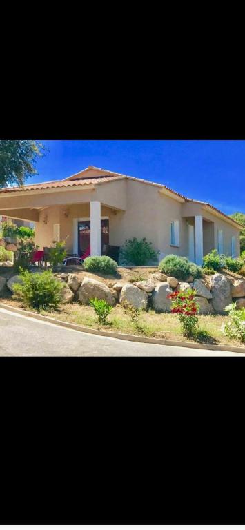 una casa con un giardino davanti di Villa les MYRTES a Olmeto