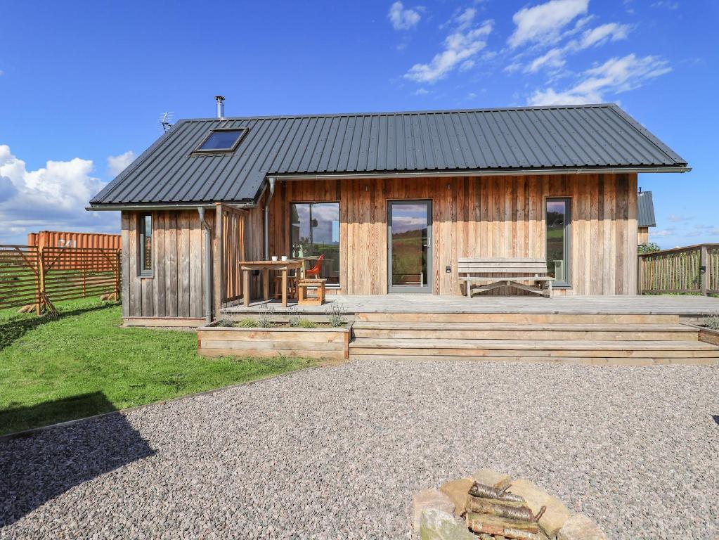 una pequeña casa de madera con una mesa de picnic delante de ella en Easter Blervie, en Forres