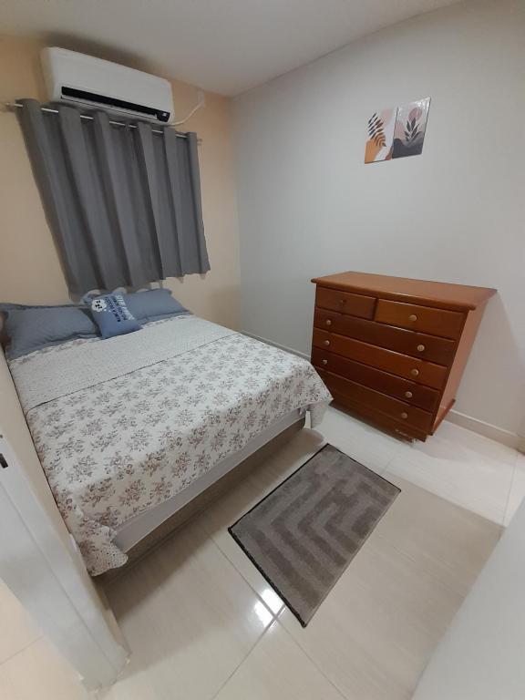 um quarto com uma cama e uma cómoda em madeira em Hospedagem do Elias em Cuiabá