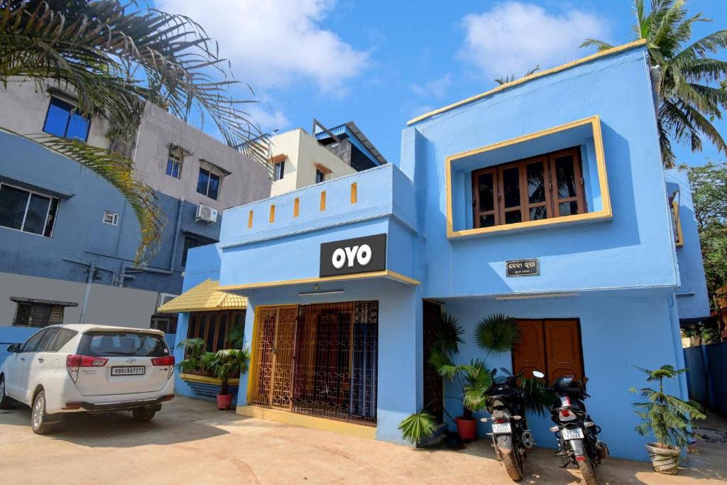 un edificio azul con un coche aparcado delante de él en OYO Flagship A1 Residency, en Bhubaneshwar