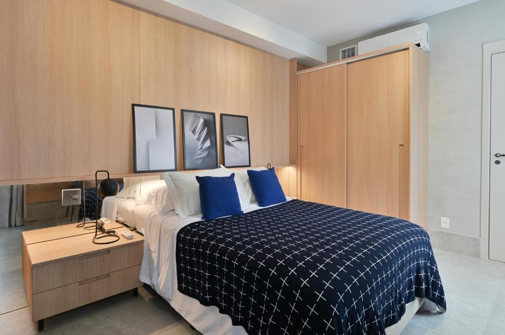 1 dormitorio con 1 cama grande con almohadas azules en Studio Prime, en São Paulo