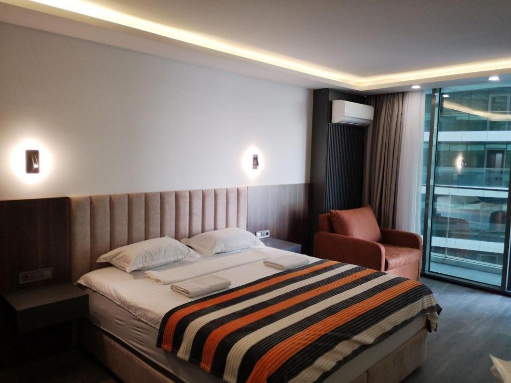 une chambre d'hôtel avec un lit et une chaise dans l'établissement Batumi View Luxury apartment, à Batoumi