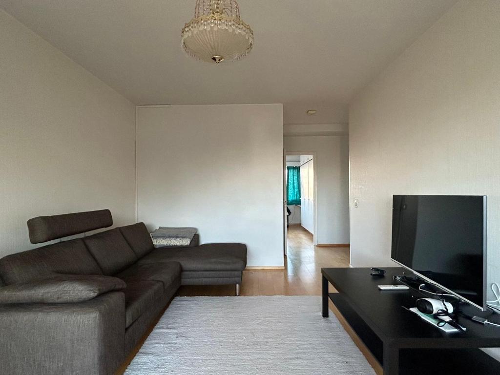un soggiorno con divano e TV a schermo piatto di An entire flat 60m2 with a balcony in Itakeskus of Helsinki a Helsinki