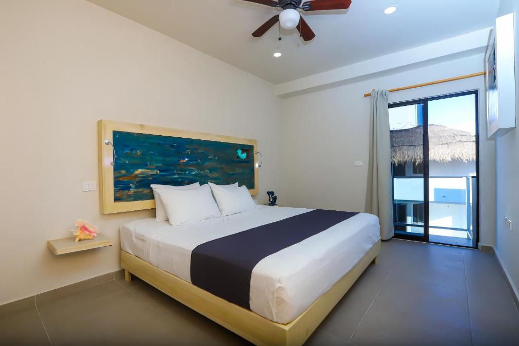 1 dormitorio con cama grande y ventana grande en Inkanto Luxury Hotel en Mahahual