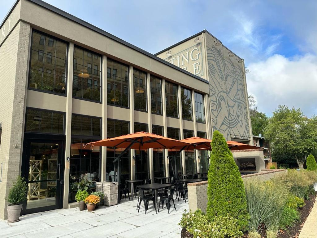 a restaurant with tables and umbrellas in front of a building at Meeting House in Falls Church