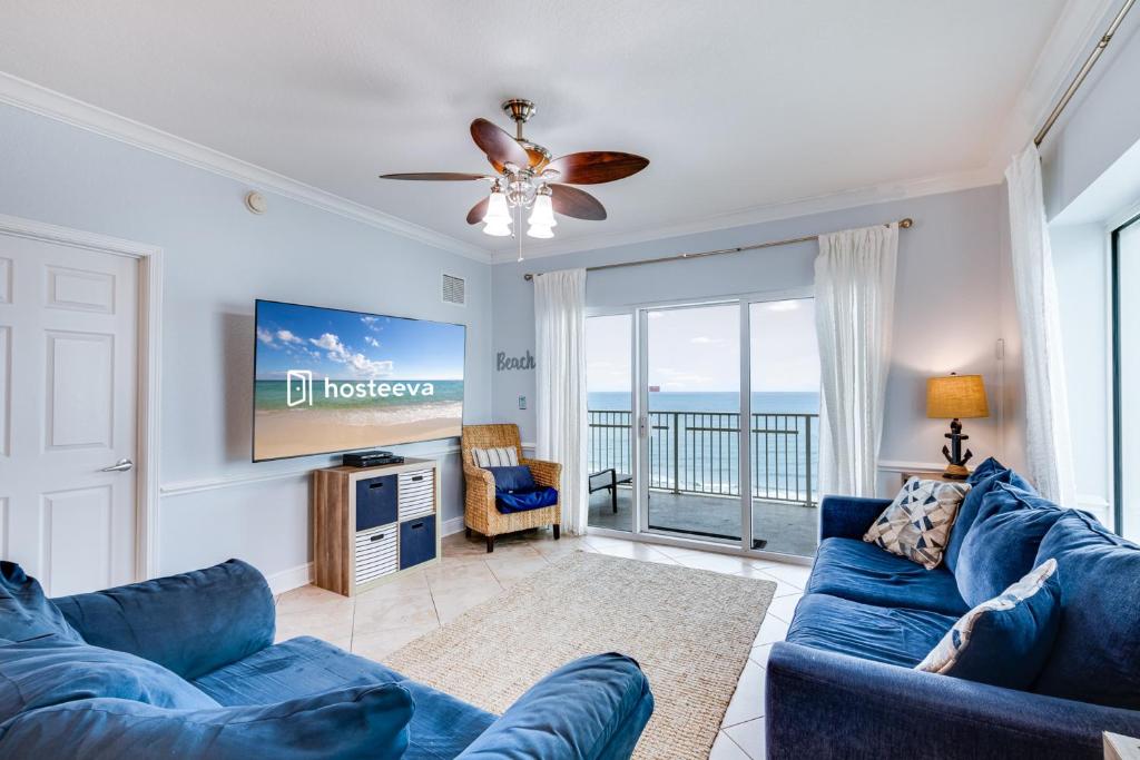 uma sala de estar com um sofá azul e uma televisão em Crystal Shores West Unit 208 em Gulf Shores