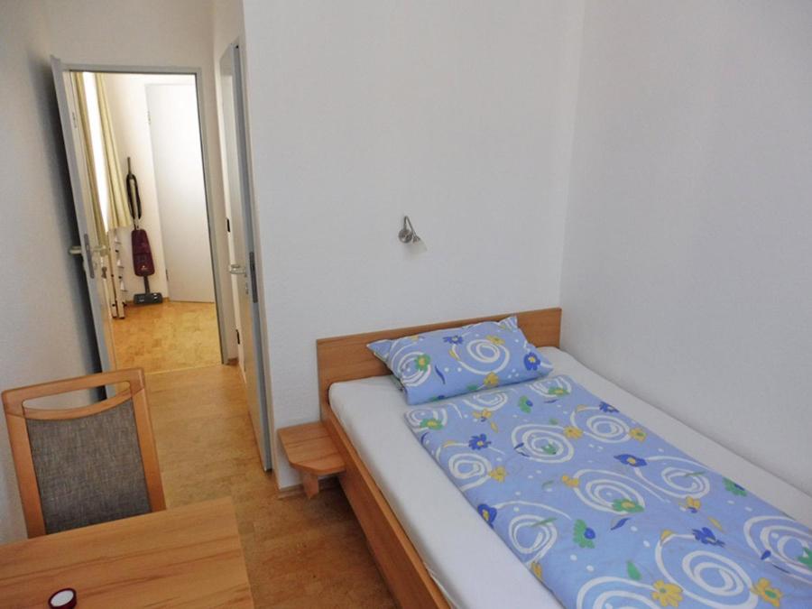 a small bedroom with a bed and a table at Haus Bielefeld Zimmer 25a in Norderney
