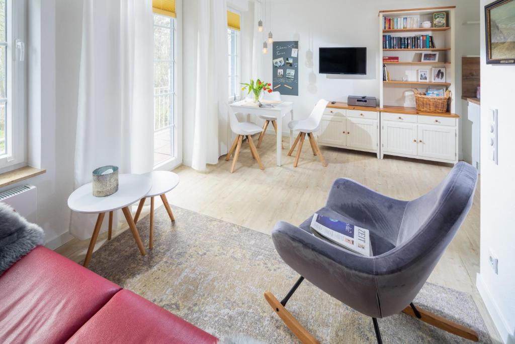 uma sala de estar com um sofá e uma cadeira em Haus Bielefeld Ferienwohnung 20 em Norderney