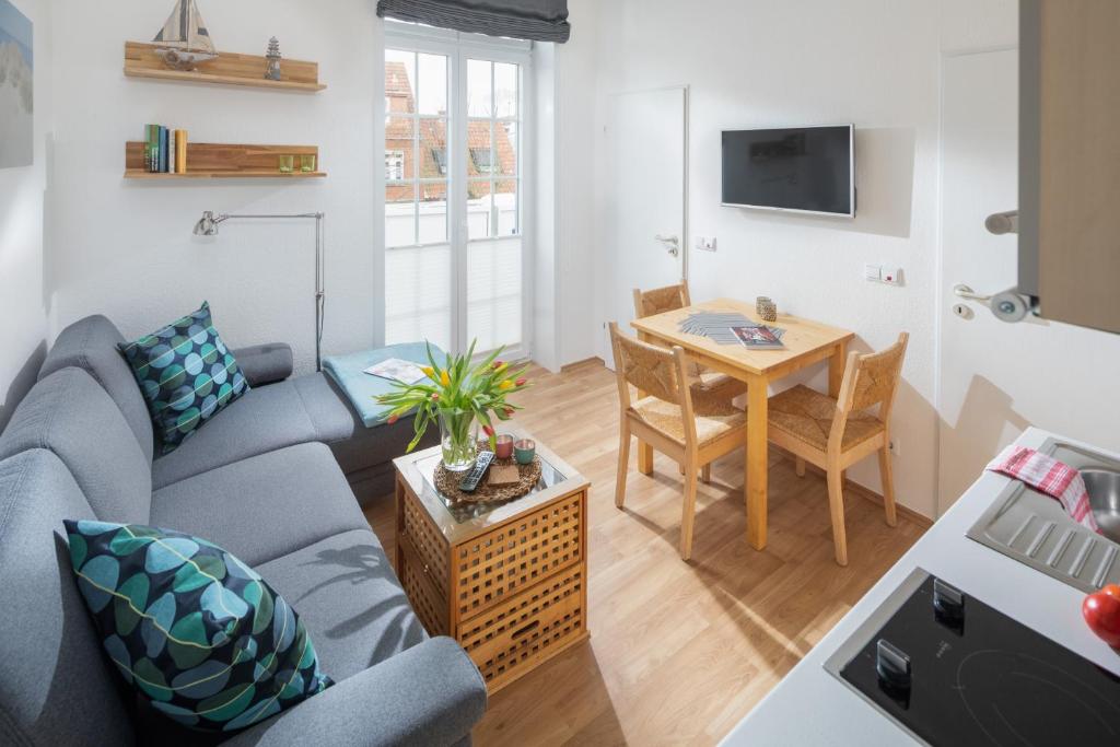 ein Wohnzimmer mit einem Sofa und einem Tisch in der Unterkunft Haus Bielefeld Ferienwohnung 12 in Norderney