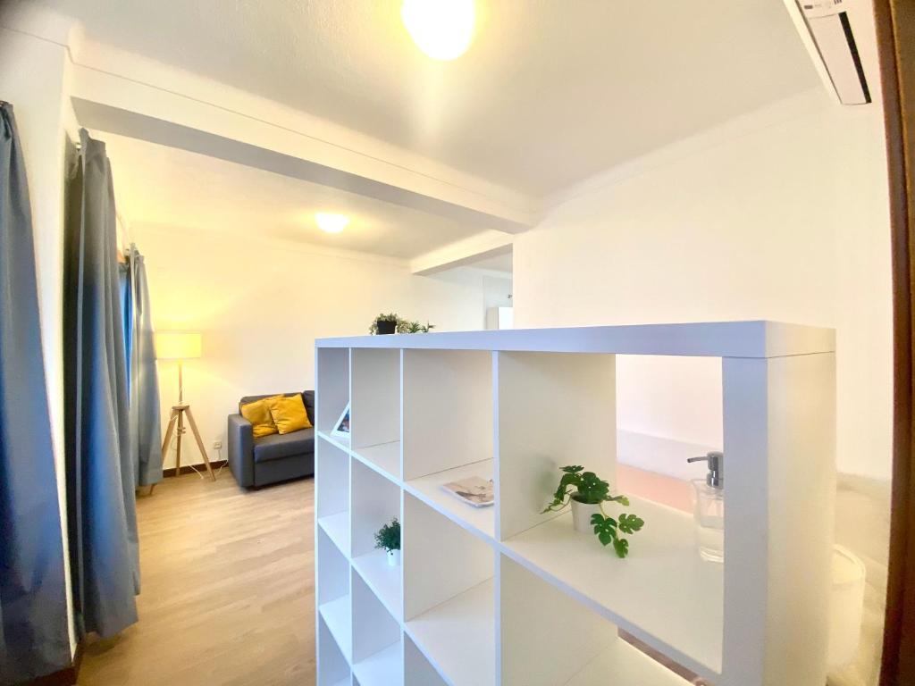 a living room with a white cabinet with plants at Ericeira Panoramic Sea View Apartments in Ericeira