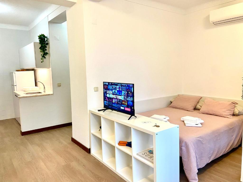 a small room with a bed and a laptop on a desk at Ericeira Panoramic Sea View Apartments in Ericeira