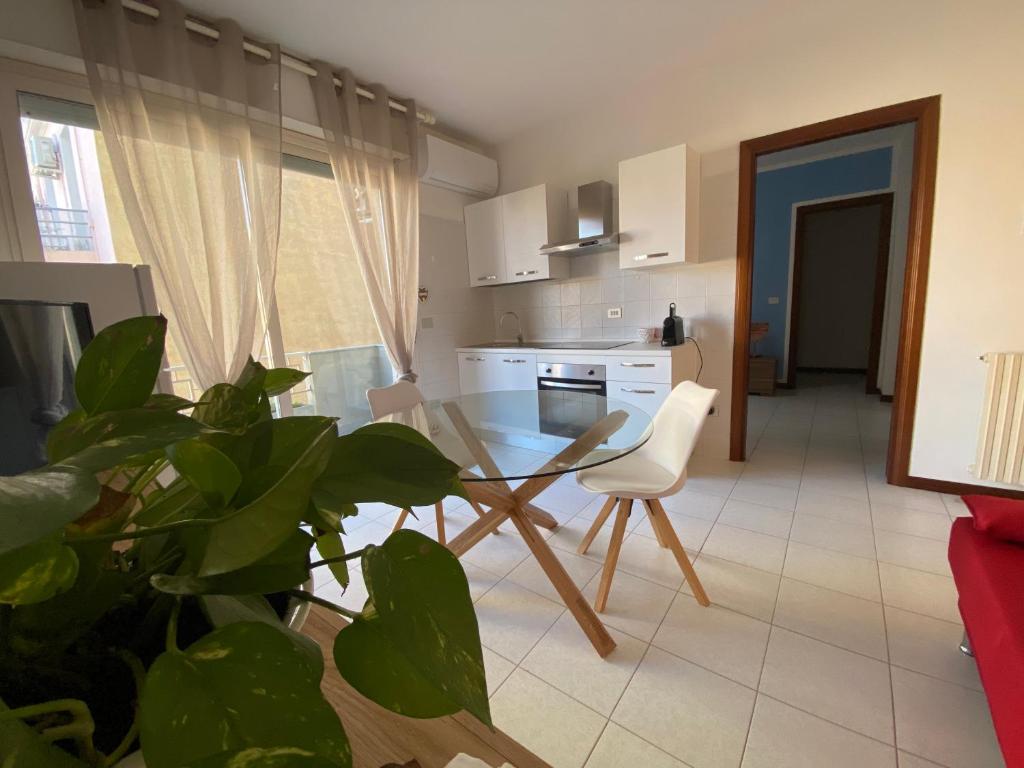 une cuisine avec une table en verre et une plante dans l'établissement Residence La Peonia, à Sassari