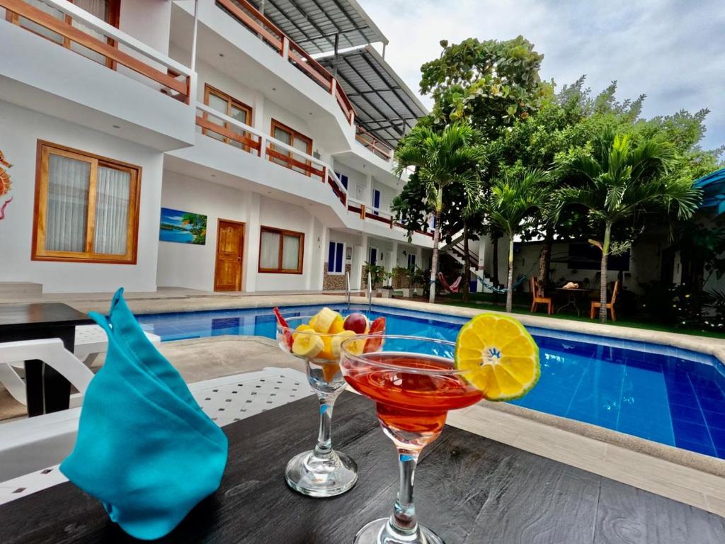 two cocktails on a table next to a swimming pool at Galápagos Isabela Hotel Loja in Puerto Villamil