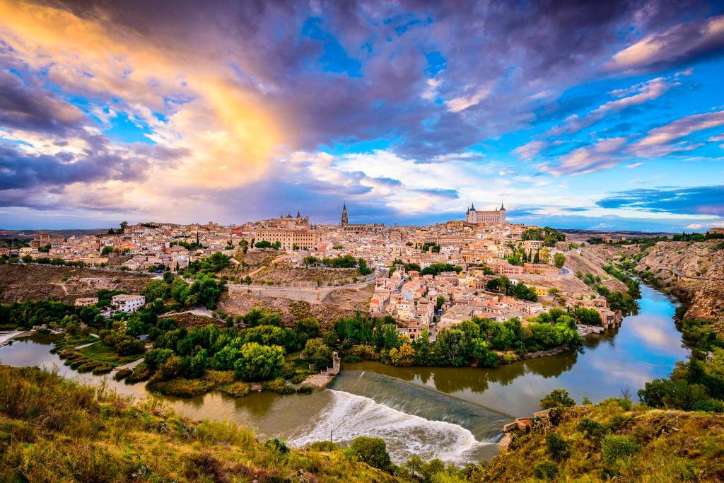 a city on a hill with a rainbow in the sky at Puy du Fou alojamiento de Julieta in Bargas