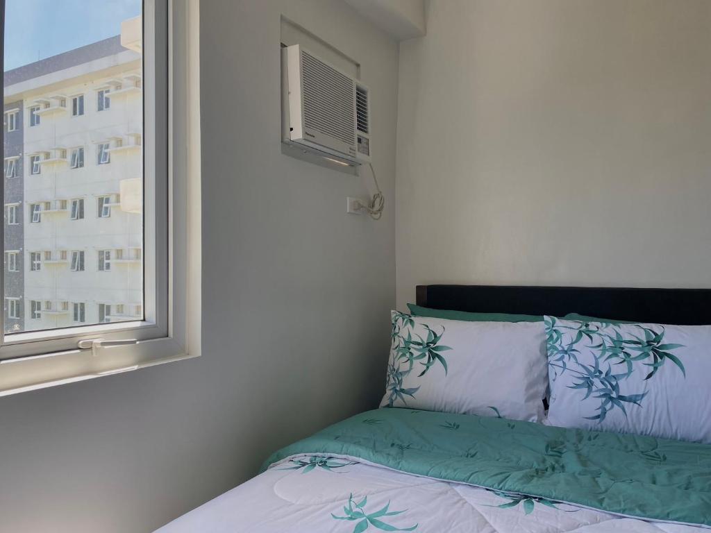 a bedroom with a bed with a window and a pillow at Condo • WIFI up to 100mbps • Pool • Netflix&Chill in Cebu City