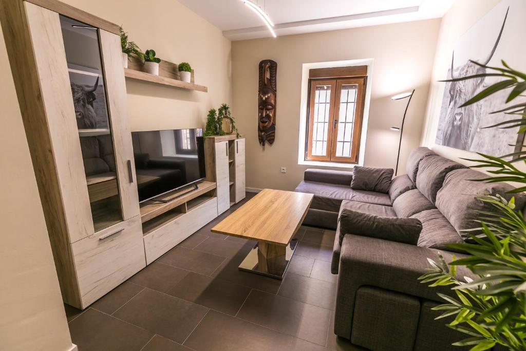 sala de estar con sofá y mesa de centro en Piso céntrico y acogedor. Opción parking gratuito. en Jaén