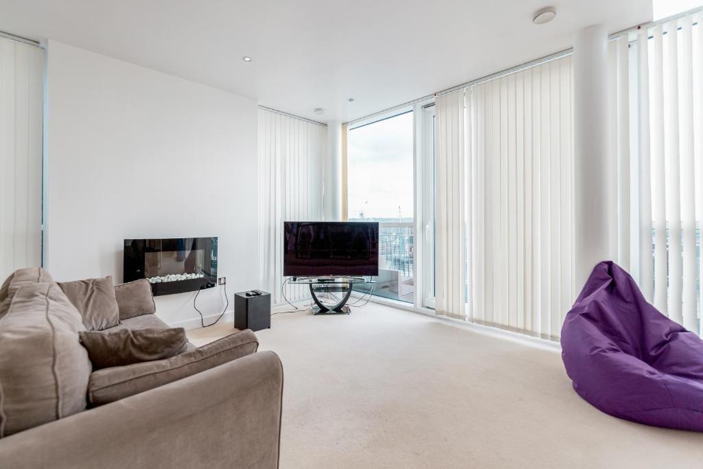 a living room with a couch and a large window at Premium Apartments By Excel in London