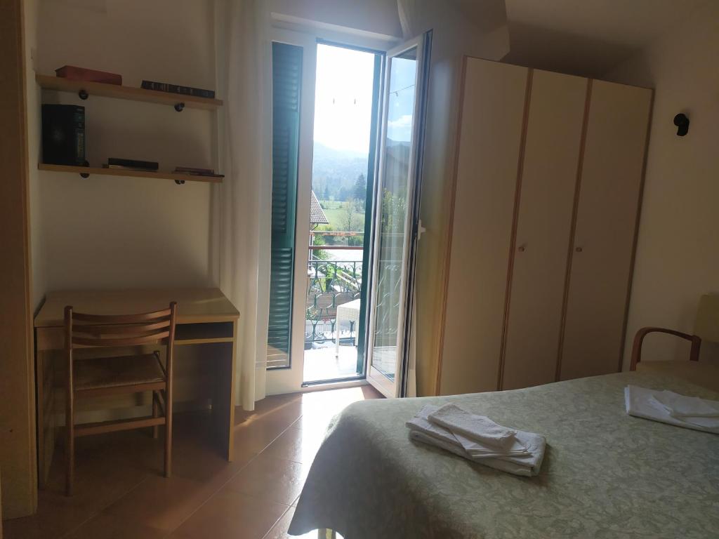Schlafzimmer mit einem Bett, einem Schreibtisch und einem Fenster in der Unterkunft Da Teresa in Bardineto