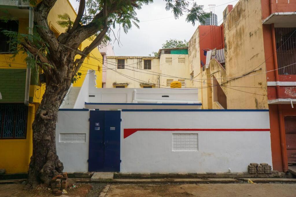 un edificio con una porta blu e un albero di Sweet Spot a Pondicherry