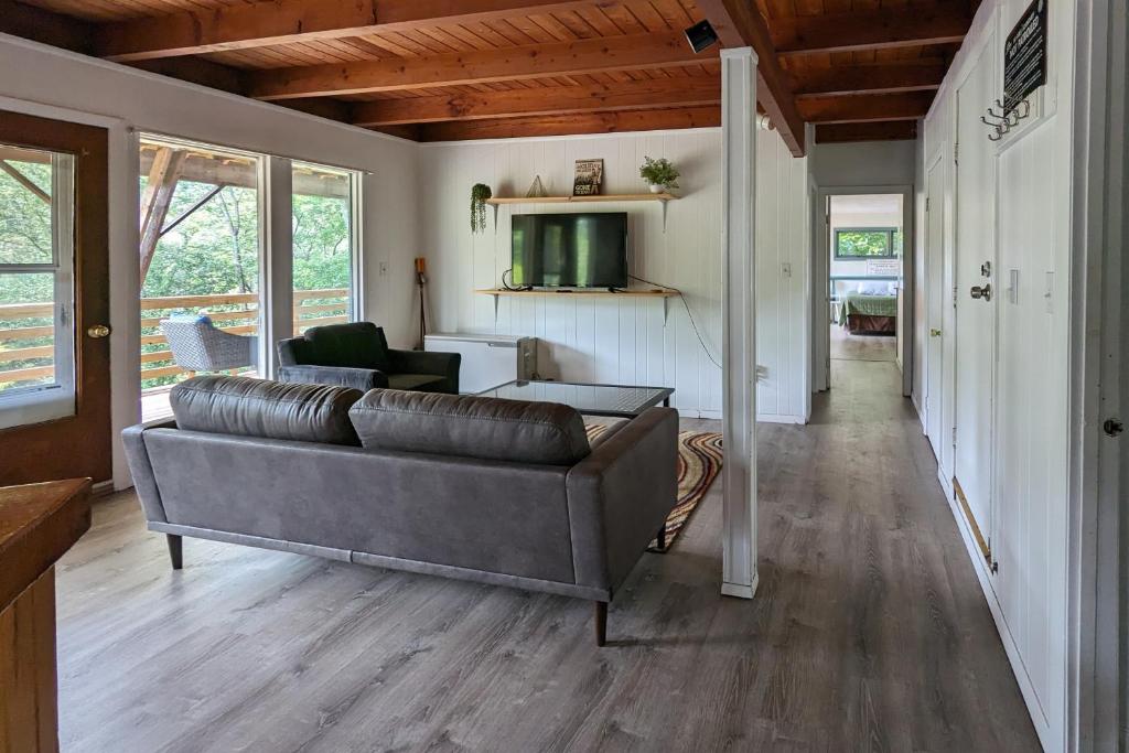 a living room with a couch and a television at Stark Mountain Sanctuary in Waitsfield