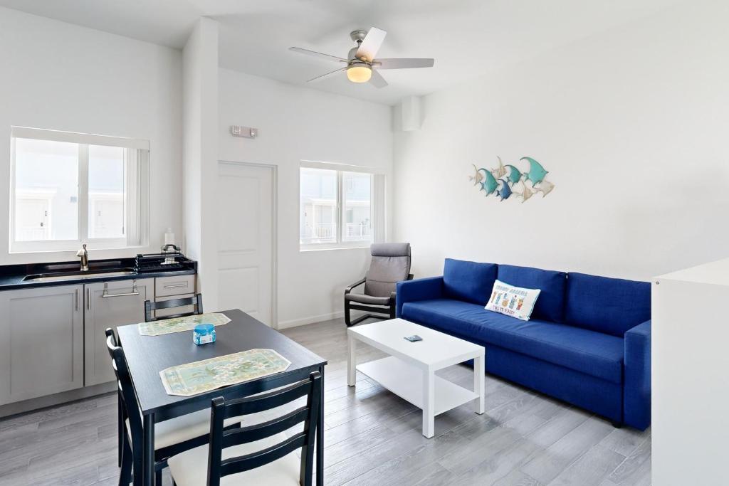 uma sala de estar com um sofá azul e uma mesa em Sea Grape Getaway em Marathon